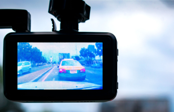 Dashboard camera recording a view of cars on a street, with a taxi visible on the screen.